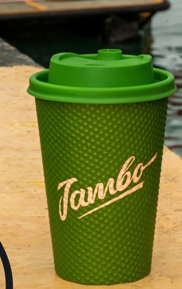 A green Jambo cup on a stone harbour wall by the water